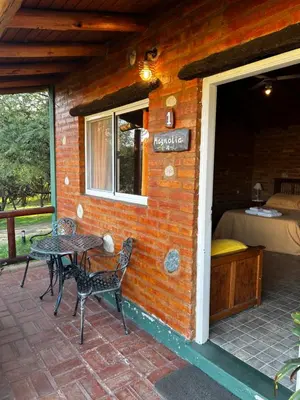a small house with a table and chairs on a patio at cabañas Villa de las rosas in Villa de Las Rosas