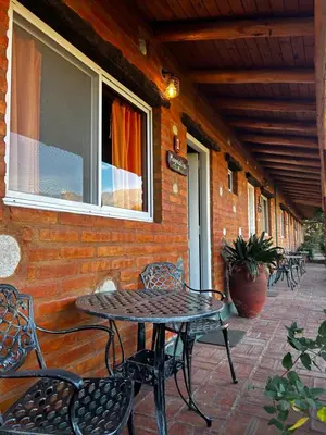 a patio with a table and chairs on a building at cabañas Villa de las rosas in Villa de Las Rosas