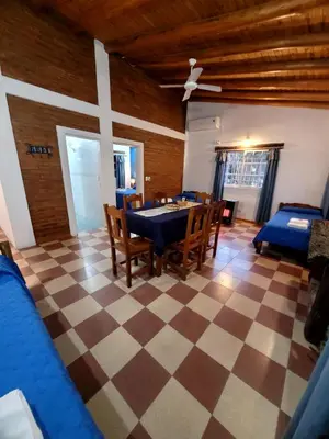 a dining room with a table and chairs on a checkered floor at cabañas Villa de las rosas in Villa de Las Rosas