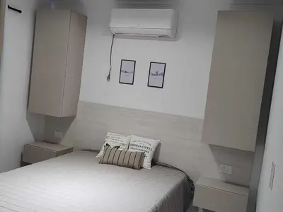 a bedroom with a bed with two pillows on it at Villa Carlos Paz departamento con pileta in Villa Carlos Paz