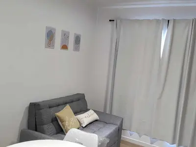 a living room with a gray couch and a window at Villa Carlos Paz departamento con pileta in Villa Carlos Paz