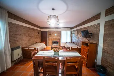 a room with a table with chairs and a bedroom at Cabañas Ocho Soles in Las Rabonas