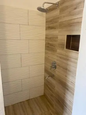 a bathroom with a shower with a wooden wall at lo de lucio in Almafuerte