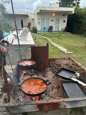 a man cooking food on a grill in a yard at lo de lucio in Almafuerte