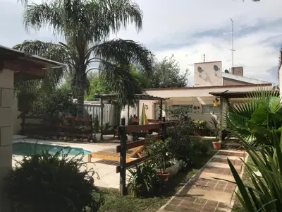 a backyard with a swimming pool and a house at FINCA URBANA departamentos in Alta Gracia