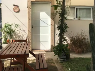 a door to a house with a bench and a table at FINCA URBANA departamentos in Alta Gracia