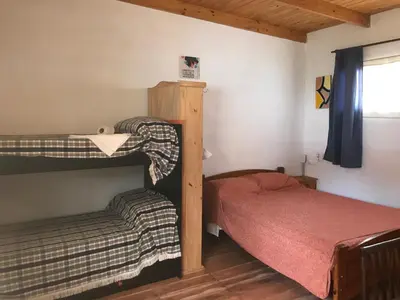 a bedroom with two bunk beds and a window at FINCA URBANA departamentos in Alta Gracia