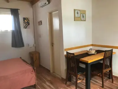 a small room with a table and chairs and a bed at FINCA URBANA departamentos in Alta Gracia