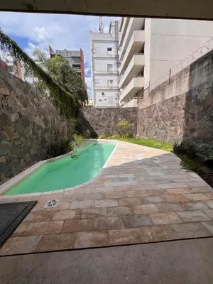 a pool of green water next to a stone wall at Departamentos en Gral Paz a pasos de clínicas in Cordoba