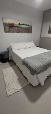 a bedroom with a bed with a rug and a painting at Excelente departamente nuevo! in Cordoba