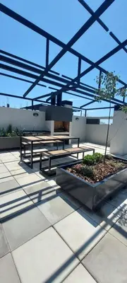 a patio with two picnic tables and a tree at Excelente departamente nuevo! in Cordoba