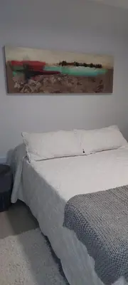 a bedroom with a bed with a painting on the wall at Excelente departamente nuevo! in Cordoba