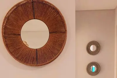 a wicker mirror on a wall in a bathroom at Excelente departamente nuevo! in Cordoba