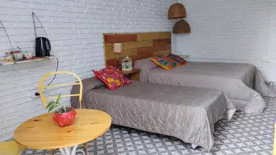 a room with two beds and a table and a table sidx sidx sidx at Casa Olivia Habitación privada in Alta Gracia