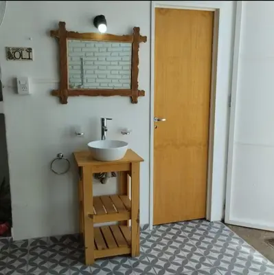 a bathroom with a sink and a wooden door at Casa Olivia Habitación privada in Alta Gracia