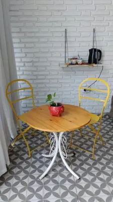 a wooden table with two chairs and a plant on it at Casa Olivia Habitación privada in Alta Gracia