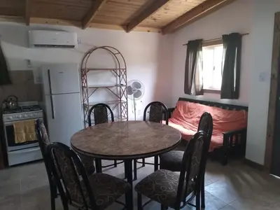 a room with a table and chairs and a bed at Colinas Del Mirador in Villa Carlos Paz