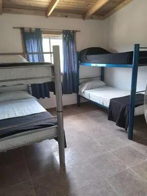 a room with two bunk beds and a tile floor at Colinas Del Mirador in Villa Carlos Paz