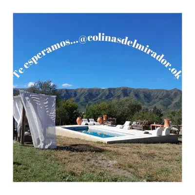 a pool with chairs and a slide in the grass at Colinas Del Mirador in Villa Carlos Paz
