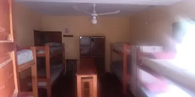 a room with several bunk beds and a ceiling at La Ribera Hotel Dormis Camping in Villa Carlos Paz