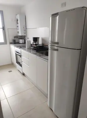 a white kitchen with a refrigerator and a stove at Hermoso Departamento confort y calidad in Cordoba