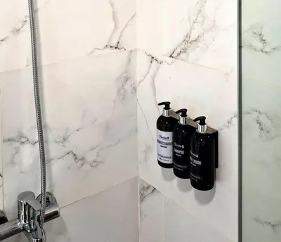 a bathroom with two shampoo bottles on a shelf at BlackStone Apart Boutique Hotel in Villa General Belgrano