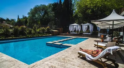 a person laying in a chair next to a swimming pool at BlackStone Apart Boutique Hotel in Villa General Belgrano