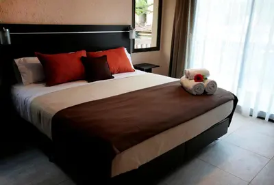 a teddy bear sitting on a bed in a bedroom at BlackStone Apart Boutique Hotel in Villa General Belgrano