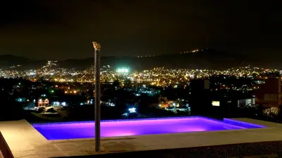 a view of a city at night with a purple pool at Alta Morada in Villa Carlos Paz