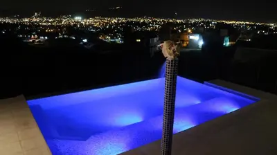 a swimming pool with blue lighting on a roof at night at Alta Morada in Villa Carlos Paz