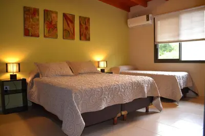 a bedroom with two beds and a window and two lamps at Alta Morada in Villa Carlos Paz