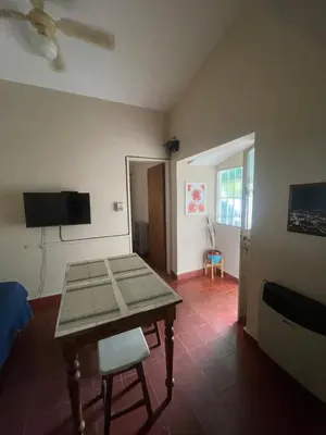 a living room with a table and a tv at Comodo departamnto con asador in Villa Carlos Paz
