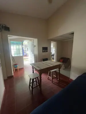 a room with a table and two chairs and a bedroom at Comodo departamnto con asador in Villa Carlos Paz