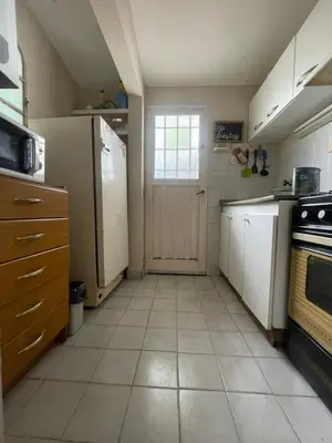 a kitchen with a refrigerator and a window and a door at Comodo departamnto con asador in Villa Carlos Paz