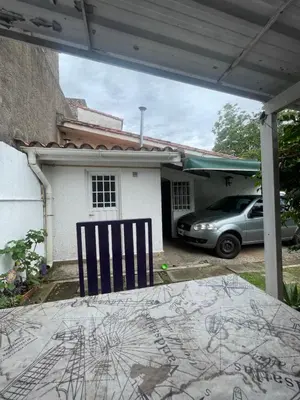 a blue chair sitting in front of a house at Comodo departamnto con asador in Villa Carlos Paz