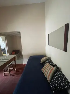 a bedroom with a bed and a table and a mirror at Comodo departamnto con asador in Villa Carlos Paz