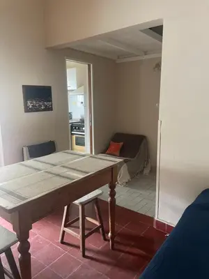 a dining room with a table and a kitchen at Comodo departamnto con asador in Villa Carlos Paz