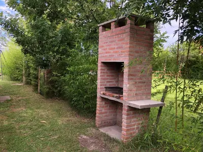 an outdoor brick oven sitting in the grass at INTI MAYU Cabañas in Mina Clavero