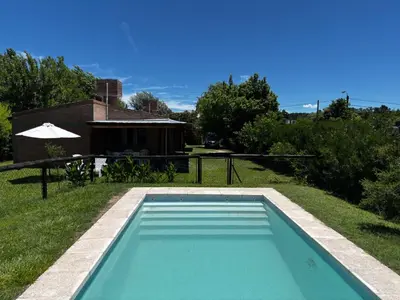 a swimming pool in the yard of a house at INTI MAYU Cabañas in Mina Clavero