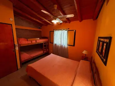 a bedroom with two bunk beds and a ceiling fan at INTI MAYU Cabañas in Mina Clavero