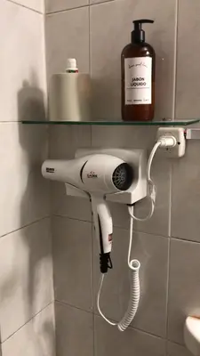 a hair dryer is hanging on a wall in a bathroom at Alojamiento Buen Pastor in Cordoba