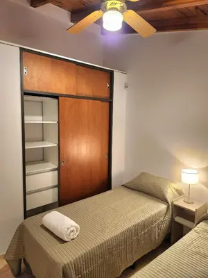 a bedroom with two beds and a closet at Vacaciones Diferentes 25 de Mayo in Villa Carlos Paz