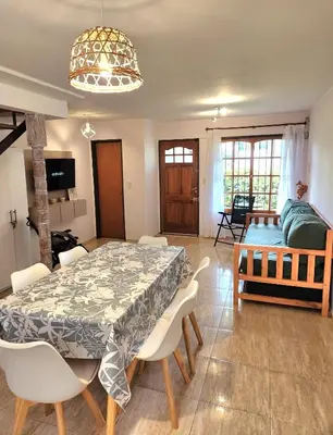 a dining room with a table and chairs and a couch at Vacaciones Diferentes 25 de Mayo in Villa Carlos Paz