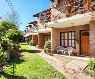 a house with a lawn in front of it at Vacaciones Diferentes 25 de Mayo in Villa Carlos Paz