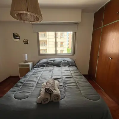 a bedroom with a large bed with a towel on it at San Lorenzo 495 bis, Nueva Córdoba in Cordoba