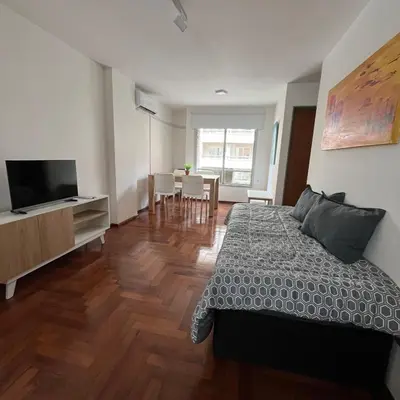 a bedroom with a bed and a dining room at San Lorenzo 495 bis, Nueva Córdoba in Cordoba