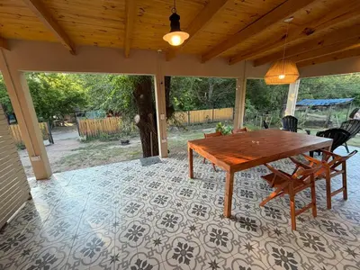 a porch with a wooden table and chairs on a patio at Casa Playa Mansa in Mina Clavero