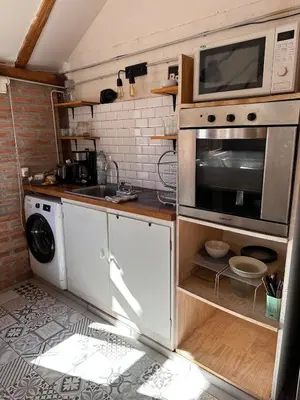 a kitchen with a microwave and a washer and dryer at Casa Playa Mansa in Mina Clavero