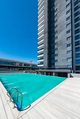 a swimming pool on the roof of a building with tall buildings at La Diva de Gama in Cordoba