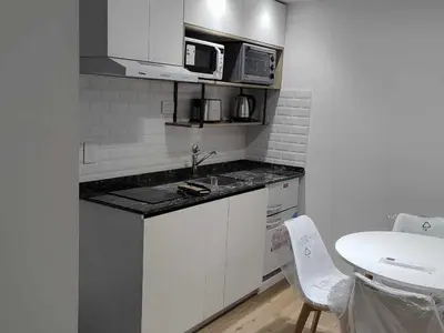 a small kitchen with a sink and a microwave at Dpto en Carlos Paz con vista al Lago in Villa Carlos Paz